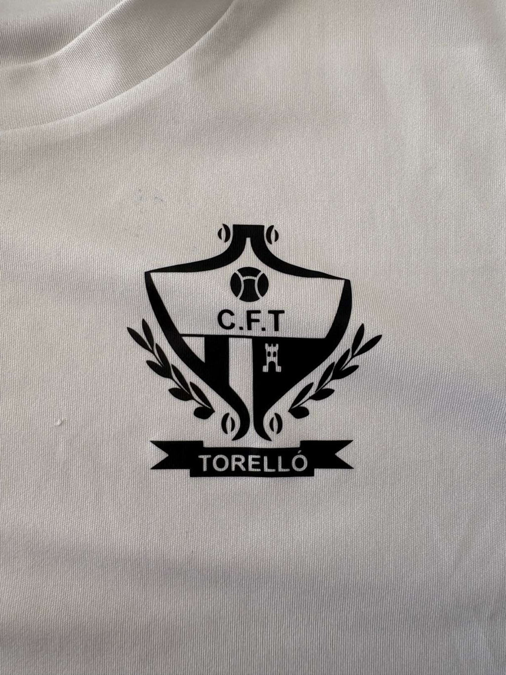 FC Torelló club crest on the 2021/22 home shirt