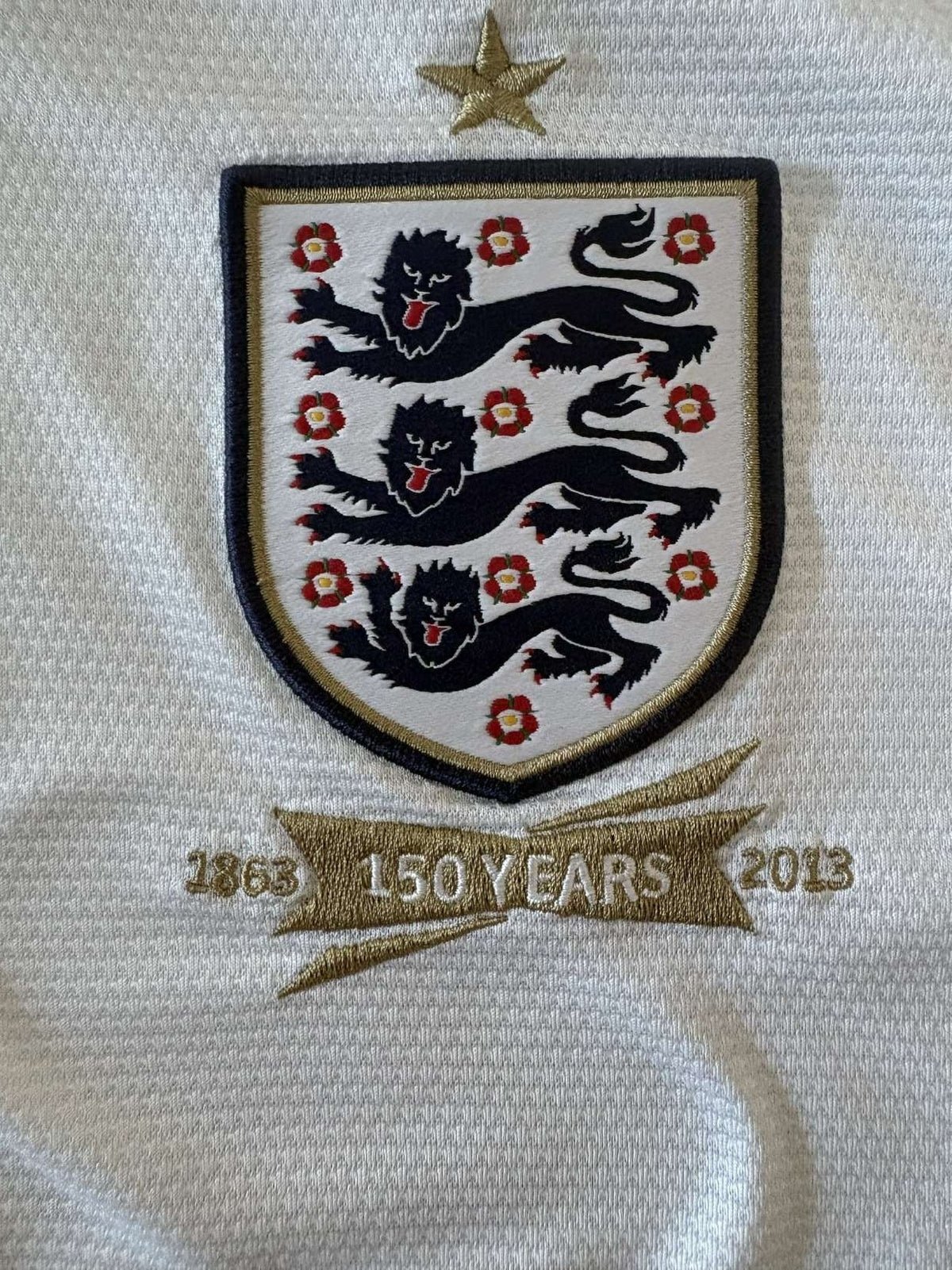England Three Lions crest on the 2013 home shirt