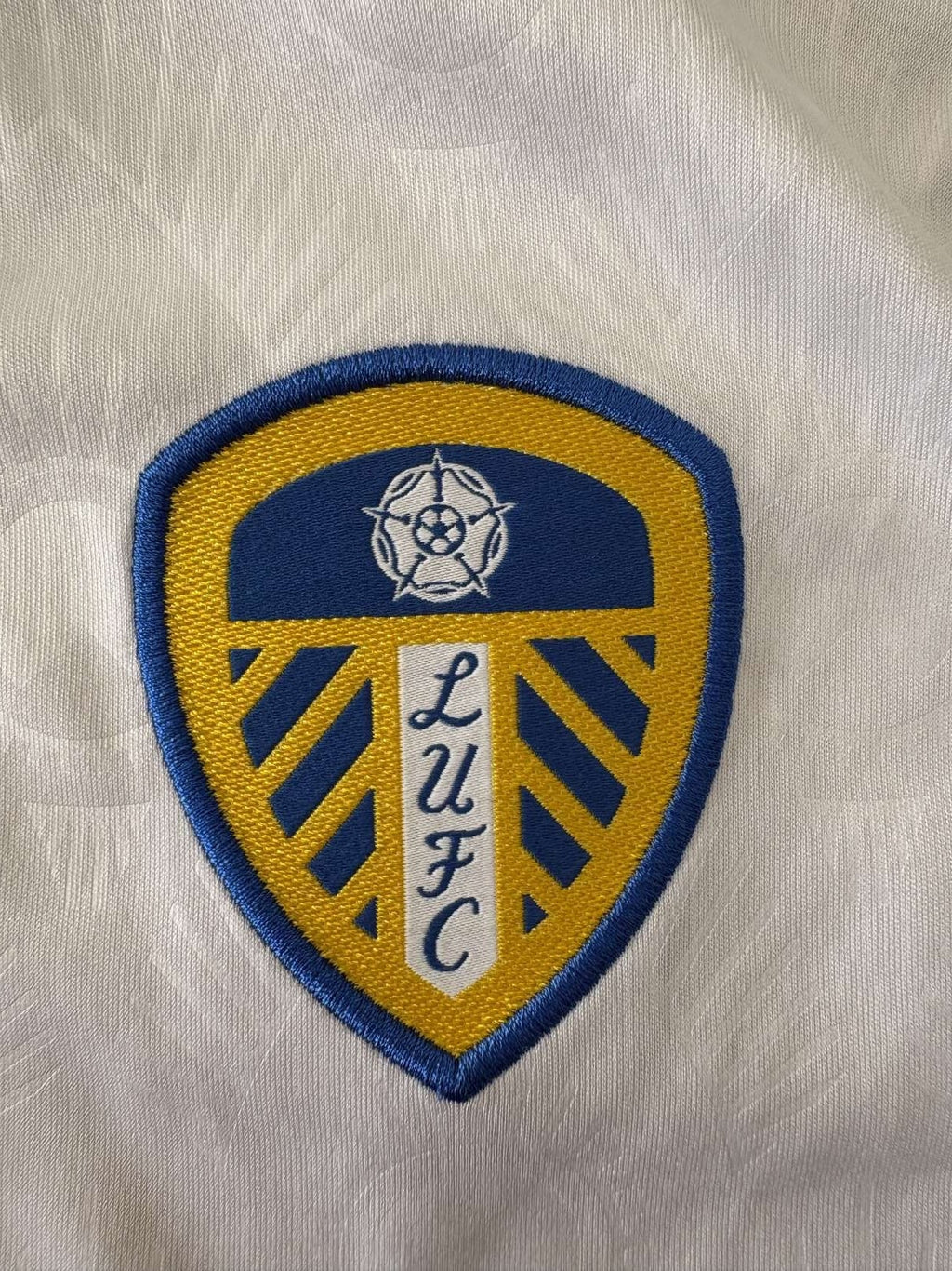 Leeds United crest on the 2023/24 home shirt